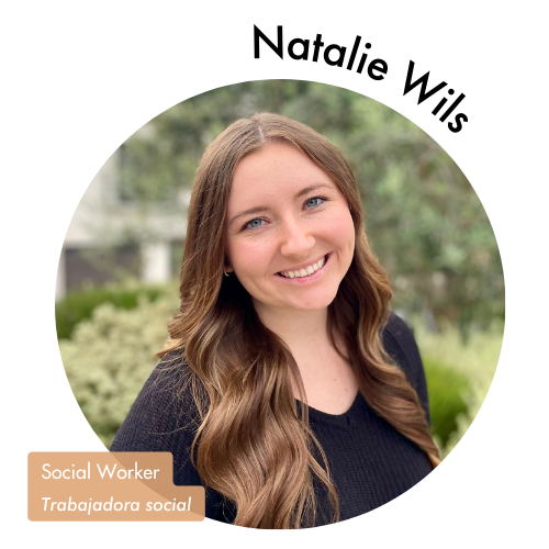 Pictured is a circle shaped image of Natalie Wils. Natalie is smiling with blue eyes and has long, curled brown hair. Her name is on the upper right in bold black letters curving around the image. On the bottom left, her position title is written in white text and highlighted in a medium tan color. Her position title is, "Social Worker, Trabajadora social"